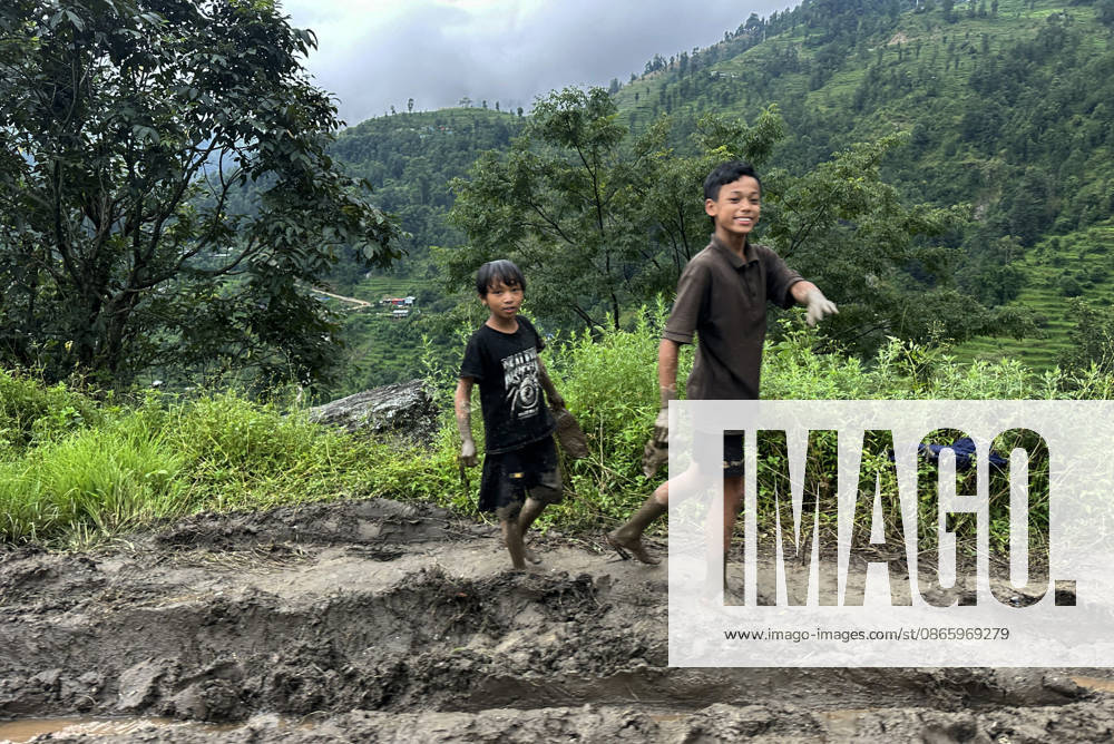 Nepali kids walk along the muddy road in Rasuwa,Nepal on September 5, 2026. Kathmandu Nepal - ZUMAs233 20260905_zap_s233_001