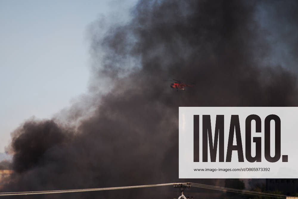 A firefighting helicopter operates amid thick black smoke while battling a fire caused by the crash of a Hellenic Air Force F-4 Phantom during the Athens Flying Week air show. Thiva Greece - ZUMAx103 20260905_zip_x103_013