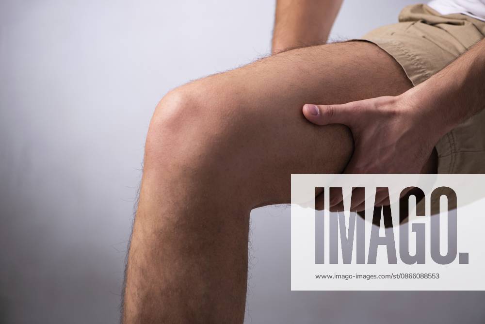 Der junge Mann leidet unter Beinschmerzen The young man is suffering from leg pain