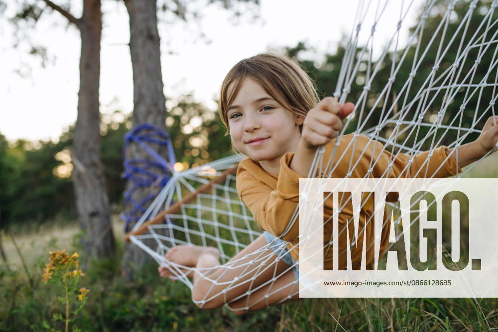 Young girl relaxing in hammock during family camping trip. Young girl enjoying hammock during summer camping adventure. model released