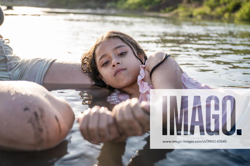 Young girl resting beside her mother in a river Reque, Lambayeque, Peru R_BILL260717-2080695-01 ,model released, Symbolfoto ,property released