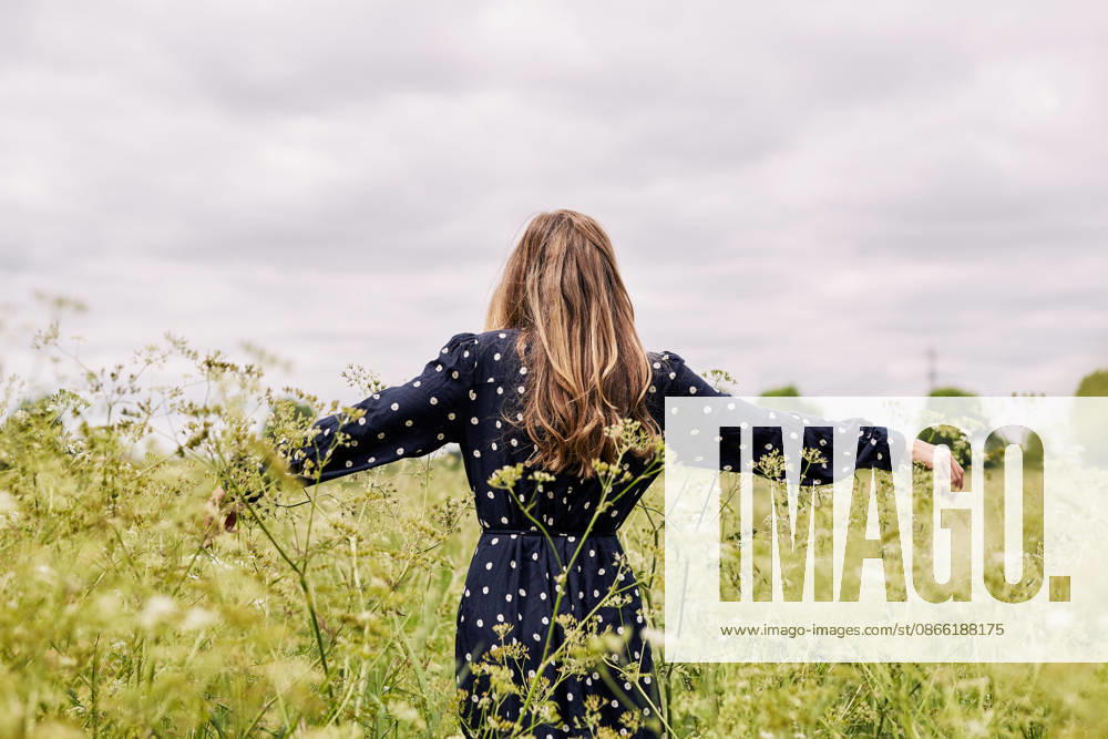 Woman in a polka dot dress standing in a field London, England, United Kingdom R_RVJWVK260902BC-2118406-01 ,model released, Symbolfoto ,property released