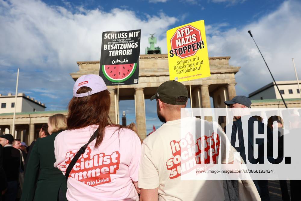 Supporters of the Left Party hold signs with anti-AfD slogans at the start of a rally with the slogan Time to Act: Stop the AfD in front of the Brandenburg Gate, Platz des