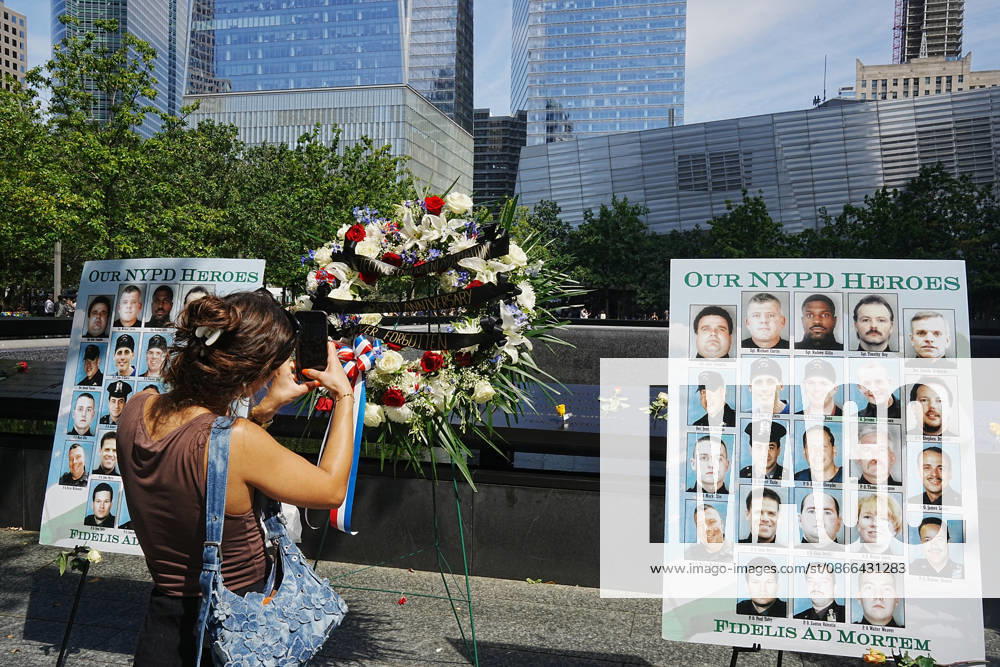 Visitors look over a memorial and flower arrangement to the NYPD along the South Tower reflecting pool ahead of the 25th anniversary of the attacks of September 11 at the 9 11 Memorial on September 9, 2026 in New York. New York USA - ZUMAb148 20260909_zap_b148_031