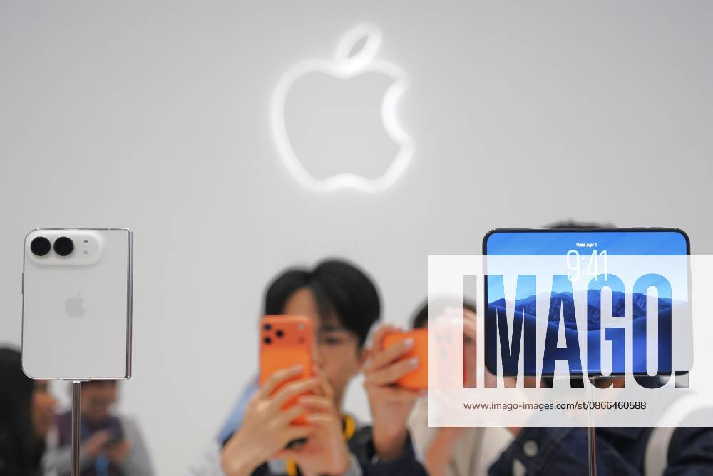 (260910) -- BEIJING, Sept. 10, 2026 -- People take photos of Apple s first foldable smartphone, iPhone Duo, at Apple Park in Cupertino, California, the United States, Sept. 9, 2026. U.S. tech giant Apple on Wednesday unveiled its first foldable smartphone, iPhone Duo, along with the iPhone 18 Pro lineup, new Apple Watch models and AirPods at a product launch event held at Apple Park, its headquarters in Cupertino, California. ) XINHUA PHOTOS OF THE DAY WuxXiaoling