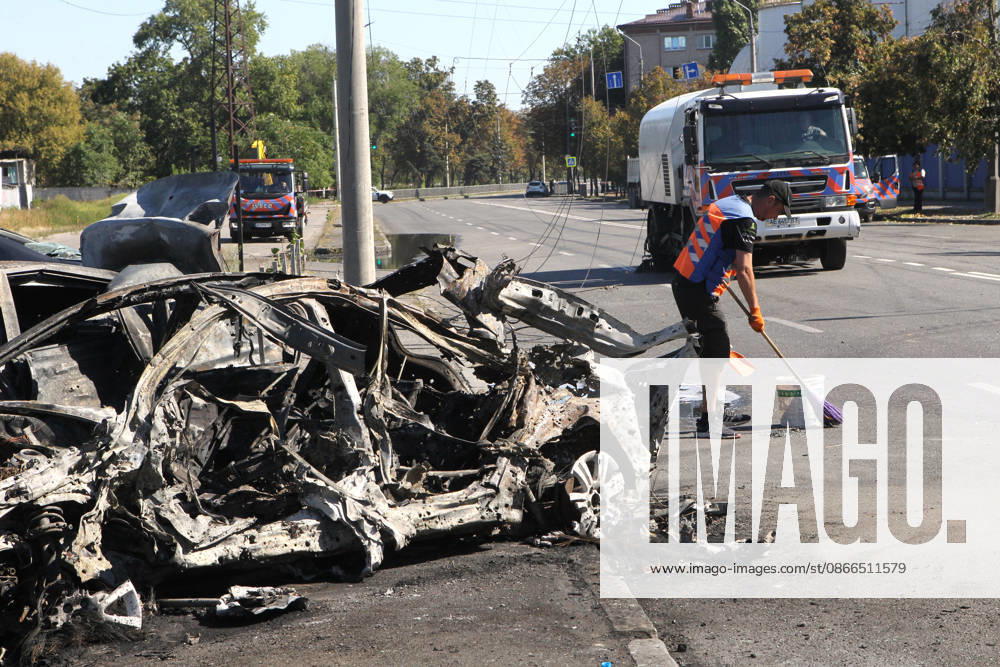A man sweeps a street near a destroyed car after a Russian Banderol cruise missile attack, Dnipro, Ukraine, September 10, 2026. Russian forces launched a double strike on the city with S8000 Banderol missiles, damaging a food industry facility. A fire broke out near the site, destroying 12 passenger cars and two minibuses. Two people were killed and at least five injured in the attack. (Photo by Mykola Miakshykov Ukrinform) Aftermath of Russian attack on Dnipro on September 10, 2026