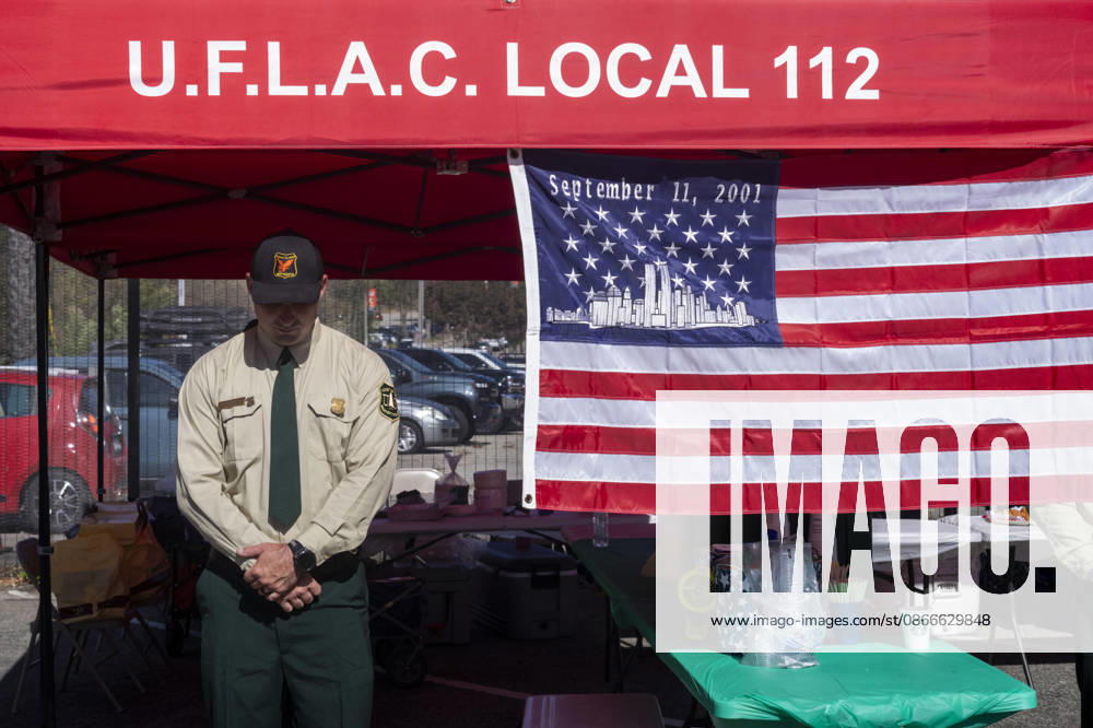 A member of the U.S. Forest Service stands next to a 9 11 remembrance flag as the Los Angeles Fire Department marks the 25th anniversary of the Sept. 11 terrorist attacks at the Frank Hotchkin Memorial Training Center in Los Angeles, California, on Sept. 11, 2026. Los Angeles USA - ZUMAc68_ 20260911_zaf_c68_016