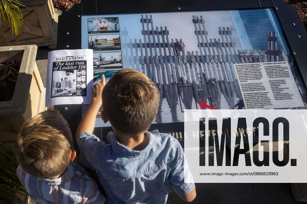 Two children examine a 9 11 memorial display featuring images of the World Trade Center site as the Los Angeles Fire Department marks the 25th anniversary of the terrorist attacks at the Frank Hotchkin Memorial Training Center in Los Angeles, California, on Sept. 11, 2026. Los Angeles USA - ZUMAc68_ 20260911_zaf_c68_008