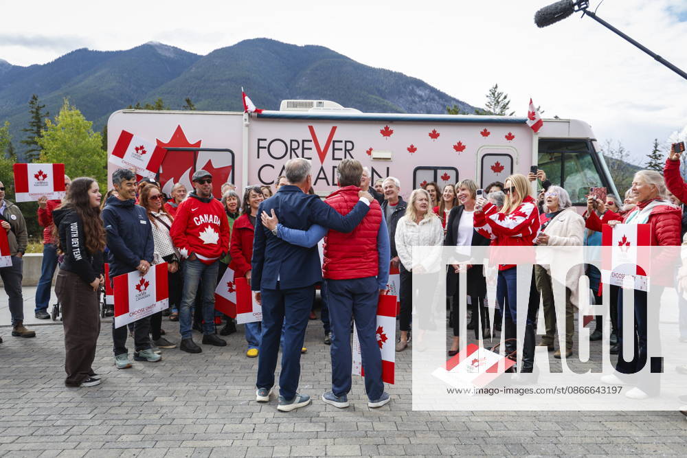 Prime Minister Mark Carney, centre left, and Forever Canadian founder Thomas Lukaszuk, centre right, stand arm in arm as volunteers sing O Canada following a cabinet retreat in Banff, Alta., Friday, Sept. 11, 2026. Banff CANADA - ZUMAc35_ 20260911_zaf_c35_119