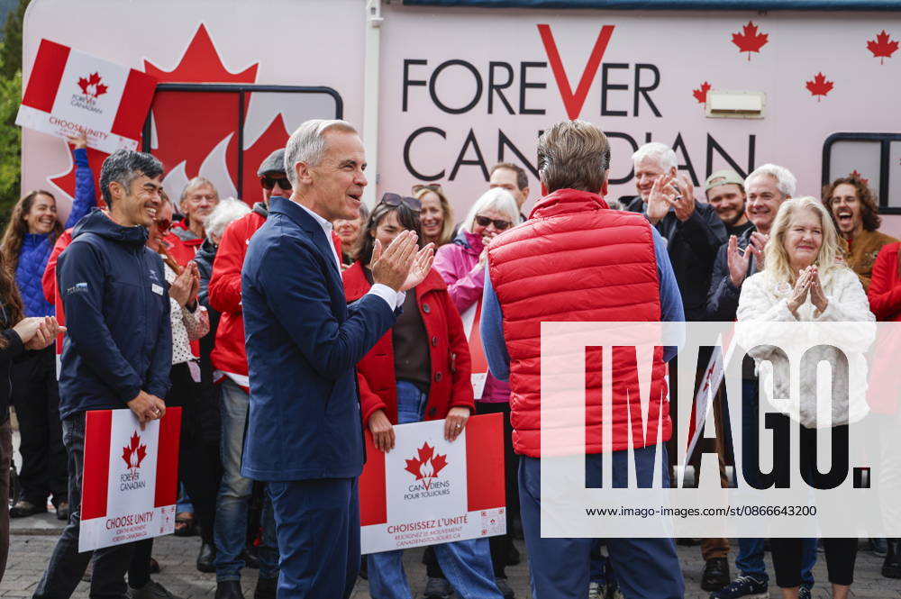 Prime Minister Mark Carney, centre left, and Forever Canadian founder Thomas Lukaszuk, centre right, applaud as volunteers sing O Canada following a cabinet retreat in Banff, Alta., Friday, Sept. 11, 2026. Banff CANADA - ZUMAc35_ 20260911_zaf_c35_120