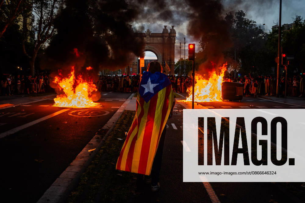 Anti-fascist protesters set fire to trash containers, erect barricades, and hurl projectiles at riot police during clashes in central Barcelona following the withdrawal of the far-right group NoÂºcleo Nacional from their planned demonstration site. The violent incidents erupted amidst tensions during the official commemorations of the Diada Nacional de Catalunya, prompting police charges and widespread damage to street furniture. Barcelona Spain - ZUMAa239 20260911_zip_a239_023