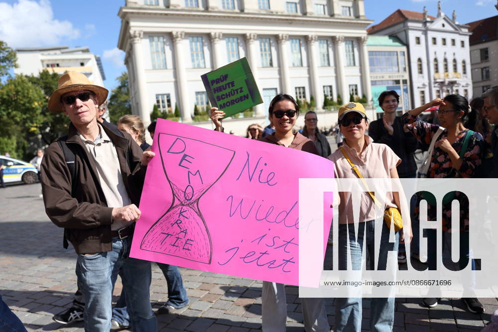 Protesters holding a sign reading Never Again stand next to an hourglass symbolizing democracy during a demonstration calling for the Federal Constitutional Court to review far-right parties, Alter Markt, Potsdam, September 12, 2026. Protest in Potsdam
