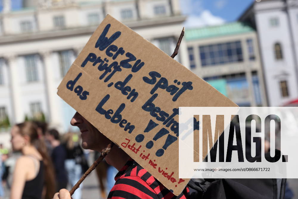 A protester holding a sign that reads, Life punishes those who wait too long to act. Now is never again, during a demonstration calling for the Federal Constitutional Court to review far-right parties, Alter Markt, Potsdam, September 12, 2026. Protest in Potsdam
