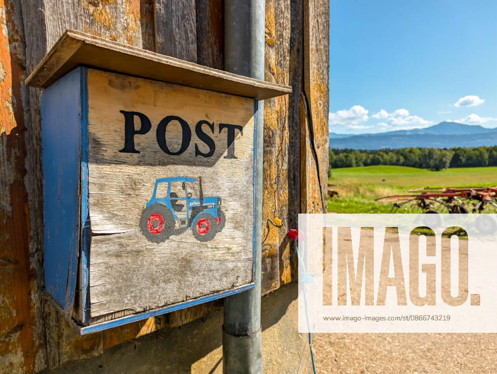 A homemade mailbox hangs on a farm in a rural area. The image symbolizes mail delivery, the mail service, and rural infrastructure, as well as the accessibility of remote farms.