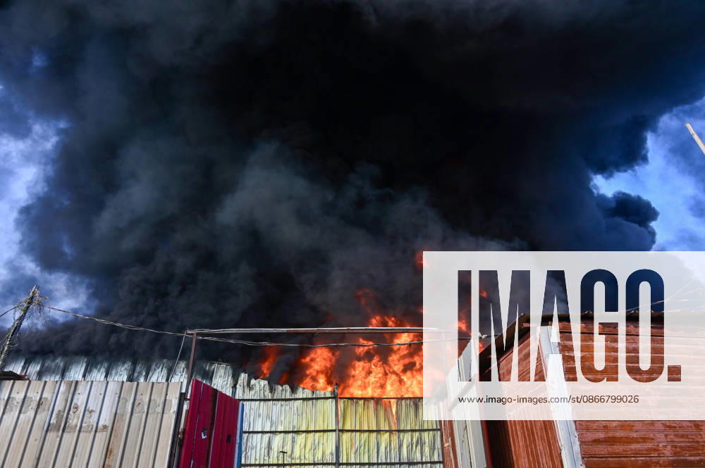 Firefighters work to extinguish a massive blaze at a plywood warehouse in Dallupura, East Delhi, as thick plumes of smoke billow into the sky and remain visible from several kilometres away, on September 13, 2026 in New Delhi, India. The fire department received a call about the blaze at 3.20 pm, following which 12 fire tenders were rushed to the spot. Firefighters were present at the site and were working to control the blaze. (Photo by Sunil Ghosh Hindustan Times ) Massive Fire Breaks Out At Delhi Plywood Warehouse, 12 Fire Tenders Rushed