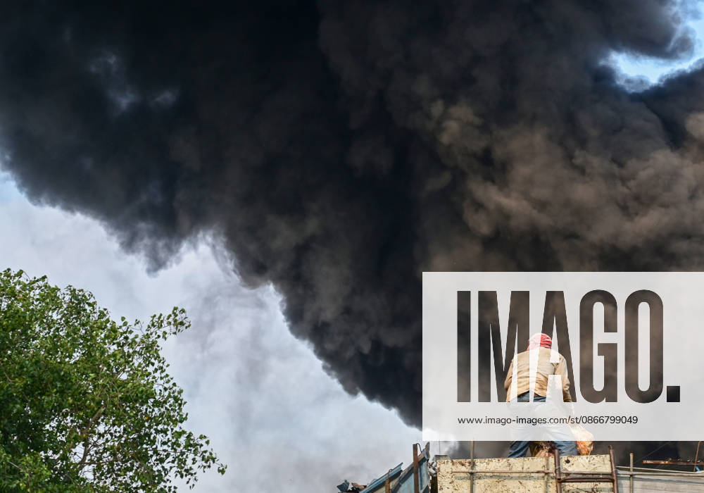 Firefighters work to extinguish a massive blaze at a plywood warehouse in Dallupura, East Delhi, as thick plumes of smoke billow into the sky and remain visible from several kilometres away, on September 13, 2026 in New Delhi, India. The fire department received a call about the blaze at 3.20 pm, following which 12 fire tenders were rushed to the spot. Firefighters were present at the site and were working to control the blaze. (Photo by Sunil Ghosh Hindustan Times ) Massive Fire Breaks Out At Delhi Plywood Warehouse, 12 Fire Tenders Rushed