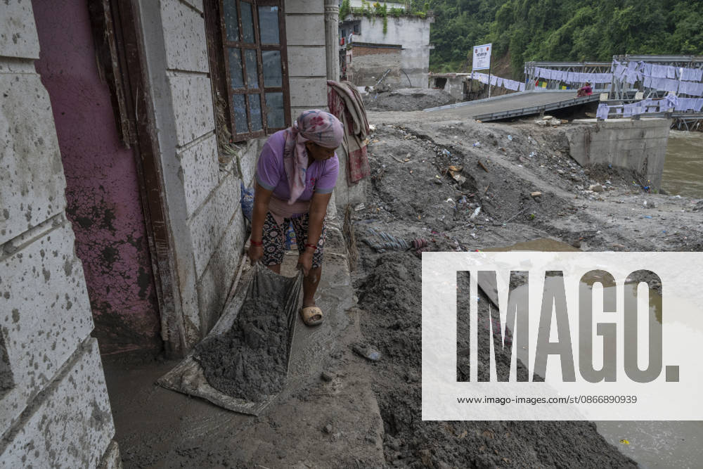 Aftermath of the devastating flash floods in Nepal NUWAKOT, NEPAL - SEPTEMBER 15: A woman clears mud following the devastating flash floods on August 26 that struck Devighat, Nuwakot, Nepal, on September 15, 2026. People in the affected areas of Nuwakot continue to return in search of their destroyed homes and the last remaining memories of their lives. Some are trying to recover essential belongings from the rubble, while others are working with family members to remove soil from parts of their homes buried underground and make them habitable again. The destruction in Devighat village is severe. Many multi-storey buildings have collapsed, while some have been buried under earth up to the level of their fifth floors. Religious figures are a