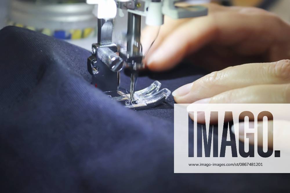 Nähkonzept. Weibliche Hände arbeiten an einer modernen Nähmaschine mit einigen Stoffen und Textilien Sewing concept. Female hands working at a modern sewing machine with some fabrics and textiles