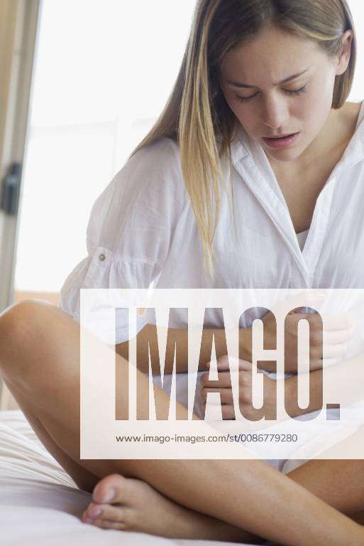Young woman clutching stomach in pain