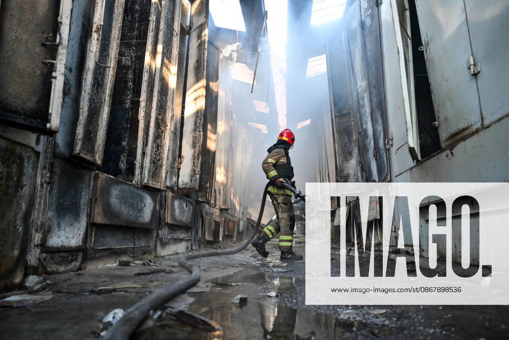A State Emergency Service rescuer carries a fire hose as he walks along a smoke-filled passageway to extinguish a fire at the Central Clothes Market (Anholenko) in Zaporizhzhia, Ukraine, September 26, 2026. The market sustained significant damage in a Russian drone attack. (Photo by Dmytro Smolienko Ukrinform) Russian troops strike clothes market in Zaporizhzhia