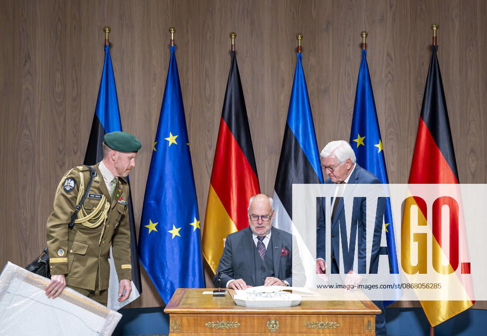 President Steinmeier Meets Alar Karis, President of the Republic of Estonia, Germany, Berlin, June 25, 2026. An Estonian officer presents a framed photo. President Frank-Walter Steinmeier welcomes Alar Karis, President of the Republic of Estonia, who signs the guest book.