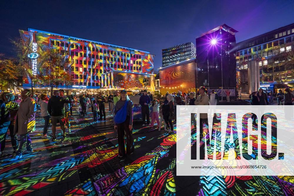 Essen Light Festival, in the city center; the light installation Diving in the Sea of Colors by Berlin-based artist Daniel Margraf illuminates the buildings on the large Kennedy Platz; visitors become part of the light art installation; North Rhine-Westphalia, Germany; Essen Light Festival