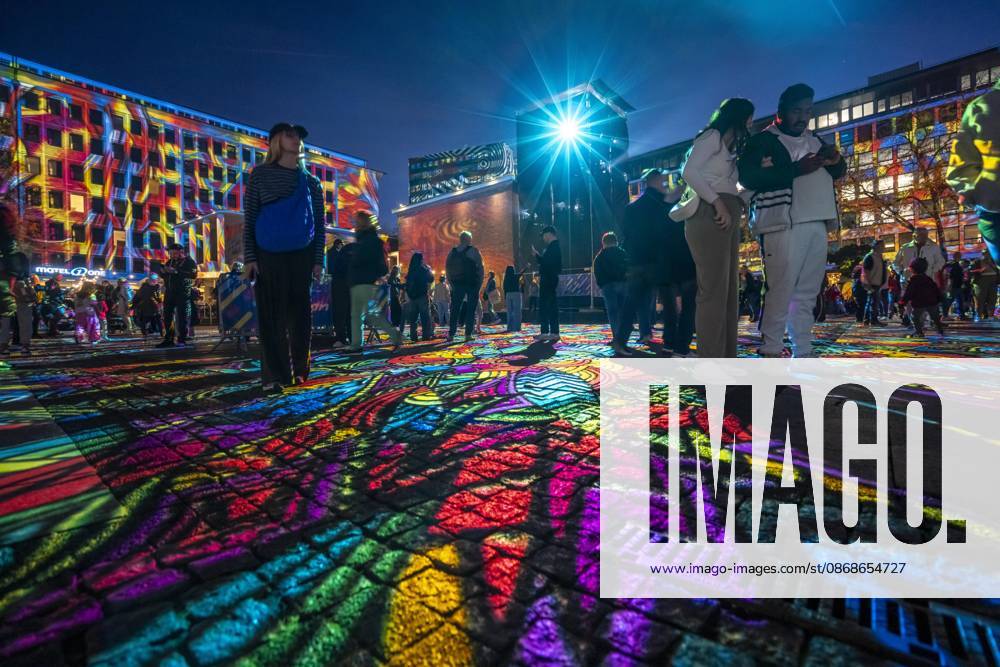 Essen Light Festival, in the city center; the light installation Diving in the Sea of Colors by Berlin-based artist Daniel Margraf illuminates the buildings on the large Kennedy Platz; visitors become part of the light art installation; North Rhine-Westphalia, Germany; Essen Light Festival
