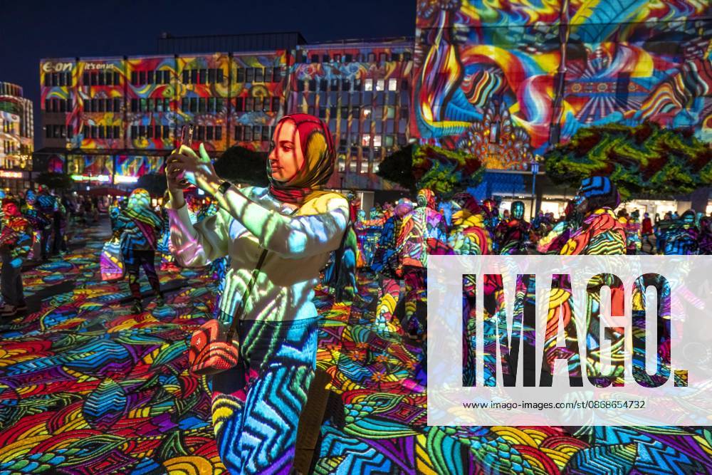Essen Light Festival, in the city center; the light installation Diving in the Sea of Colors by Berlin-based artist Daniel Margraf illuminates the buildings on the large Kennedy Platz; visitors become part of the light art installation; North Rhine-Westphalia, Germany; Essen Light Festival