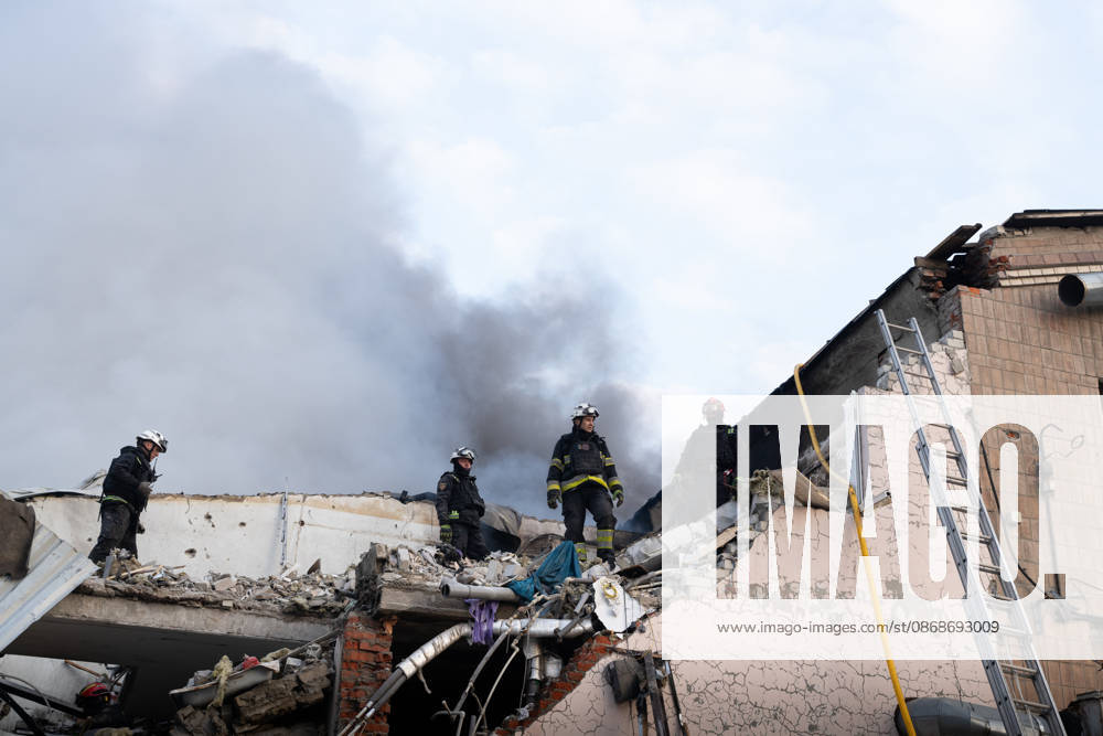 Local rescue workers, firefighters and Red Cross volunteers clear rubble following a Russian aerial attack on a bus repair warehouse which killed two people in Kharkiv, Ukraine. Emergency crews search through the heavily damaged building and collapsed sections of the warehouse for survivors and the remains of those killed in the attack. Kharkiv Ukraine - ZUMAm350 20261005_zip_m350_012