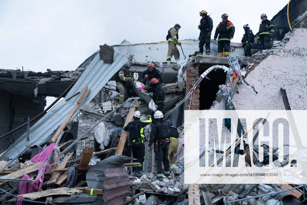 Local rescue workers, firefighters and Red Cross volunteers clear rubble following a Russian aerial attack on a bus repair warehouse which killed two people in Kharkiv, Ukraine. Emergency crews search through the heavily damaged building and collapsed sections of the warehouse for survivors and the remains of those killed in the attack. Kharkiv Ukraine - ZUMAm350 20261005_zip_m350_015