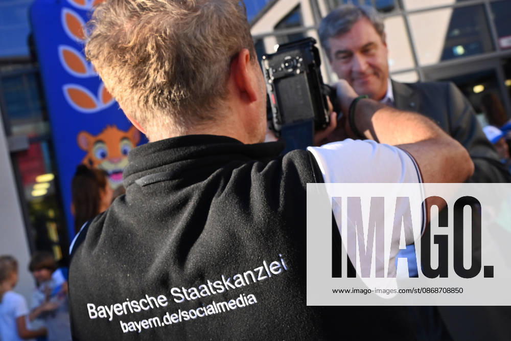 The back of a person with the words Bavarian State Chancellery, Social media takes center stage at a school visit with Minister-President Markus Söder Markus SÖDER, Minister-President of Bavaria and CSU