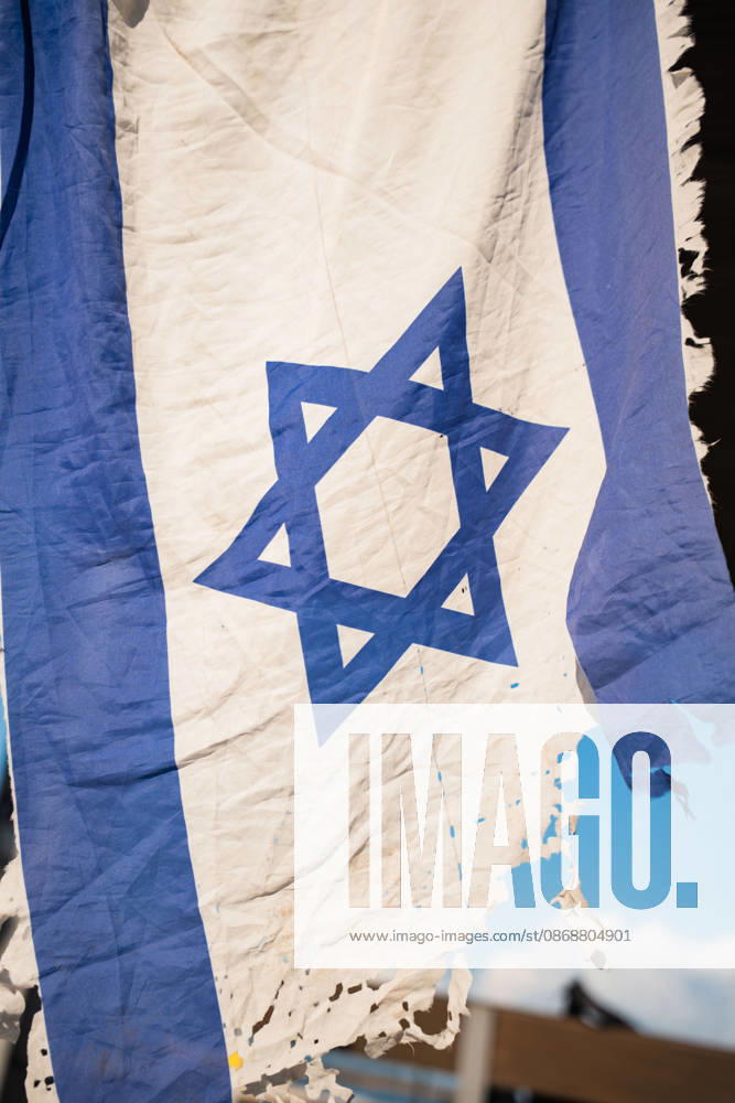A tattered Israeli flag is held up in protest against the Israeli government on the third anniversary of October 7th. Tel Aviv Israel - ZUMAg280 20261007_znp_g280_002