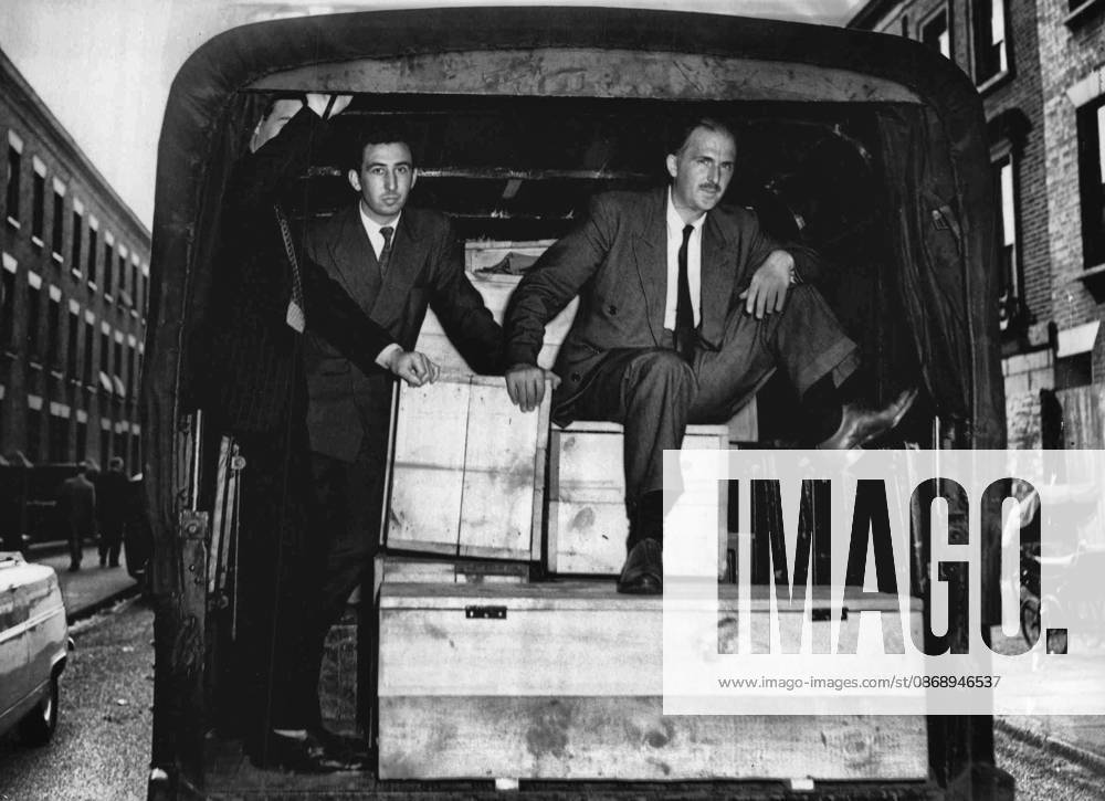 The Shop With The Deadly Secret -- Outside the shop a detective sits in a police van - on an ammunition box packed with guns. August 17, 1955. (Photo by Daily Mirror).