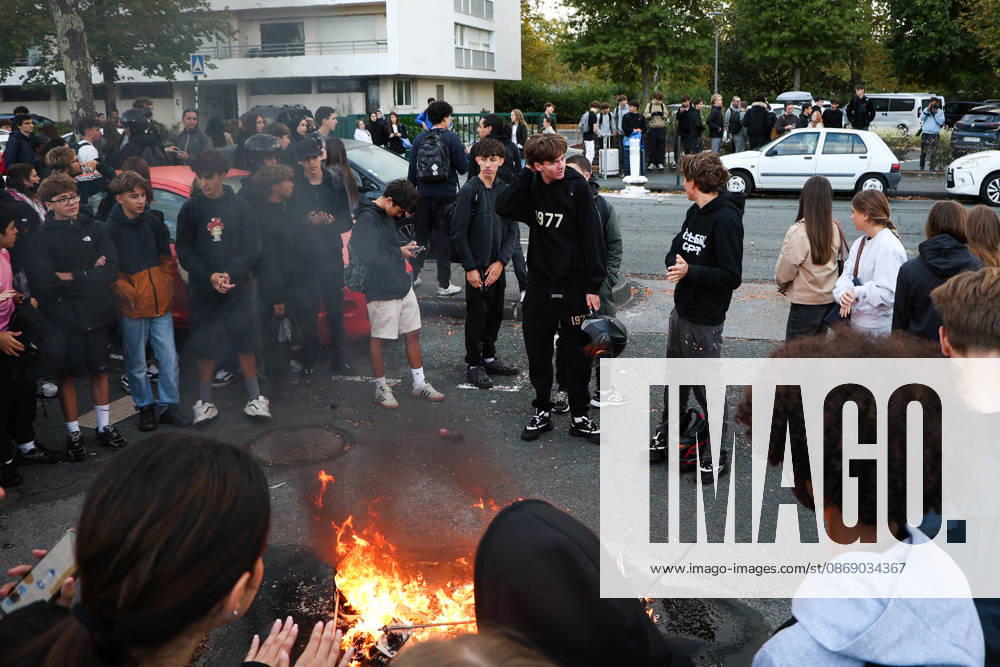 Pupils gather around a fire lit in the street outside the Reno Cassin high school in Bayonne, south-western France, on October 9, 2026, during a nationwide protest movement over learning conditions. Since late September, pupils have blocked hundreds of schools to denounce teacher shortages, overcrowded classes and dilapidated buildings, with university students and unions joining in. Between 266,000 and 450,000 people marched across France on October 6, according to authorities and organisers, after clashes in several cities. The government says it is betting on dialogue within schools to calm the unrest. Bayonne France - ZUMAb298 20261009_zsp_b298_002