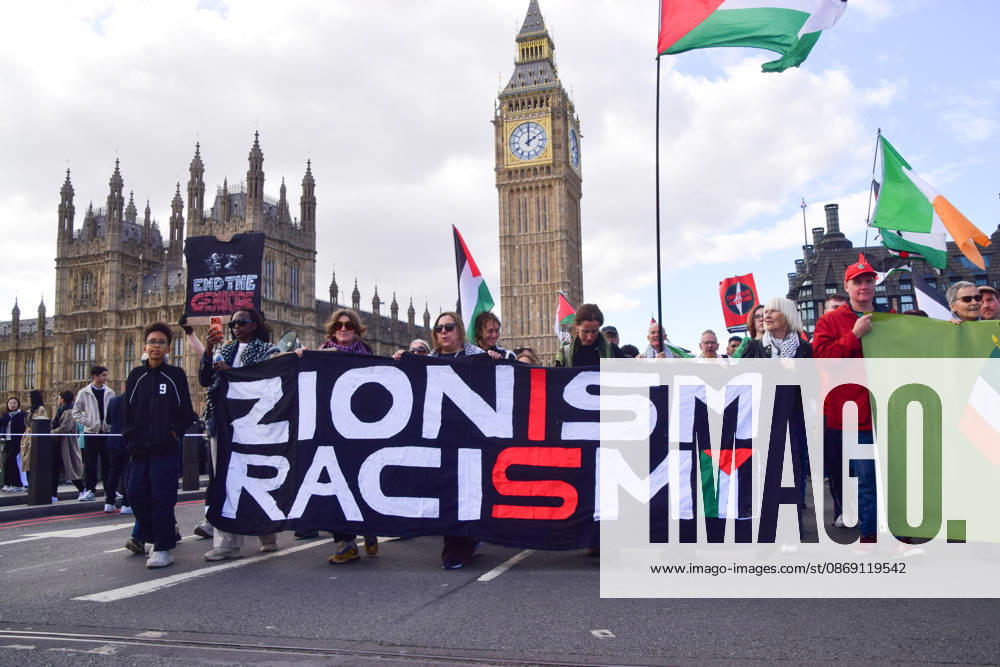 Protesters holding a Zionism is Racism banner pass over Westminster Bridge past the Houses of Parliament as thousands of people march in support of Palestine. The protesters also called on the government to stop arming Israel and for sanctions on Israel. London United Kingdom - ZUMAv130 20261010_zip_v130_038