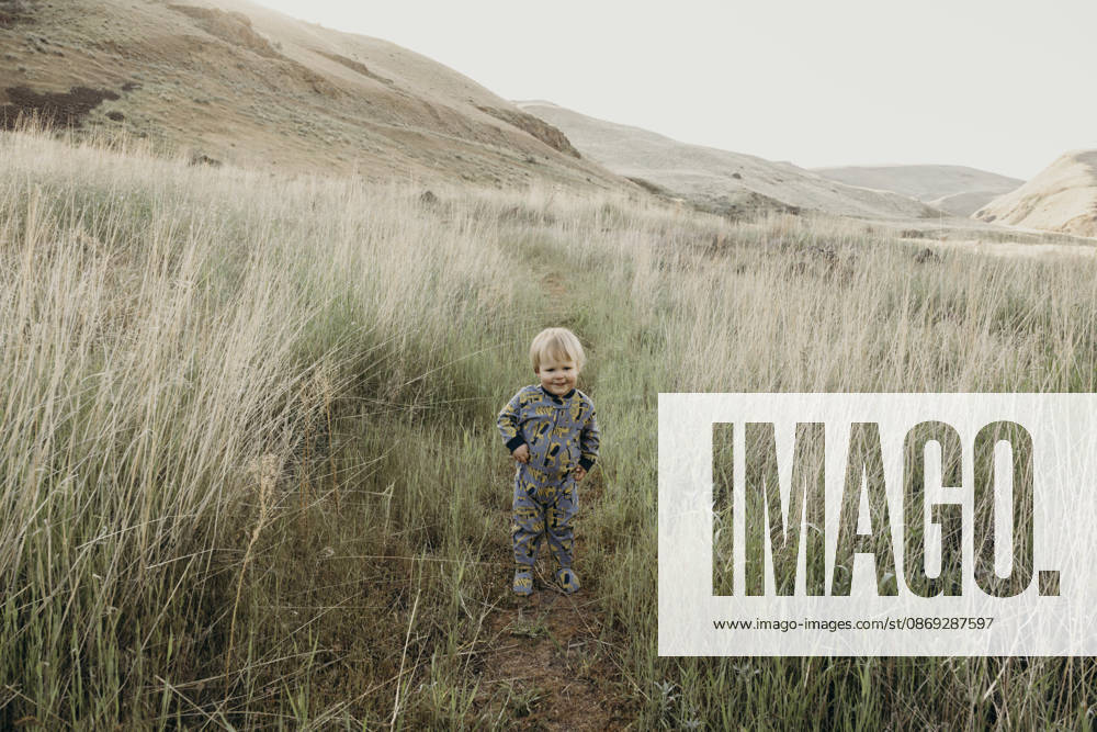 Cute toddler boy standing on a path in a big grassy field The Dalles, Oregon, United States CR_XICZ261001B9-2131818-01 ,model released, Symbolfoto ,property released