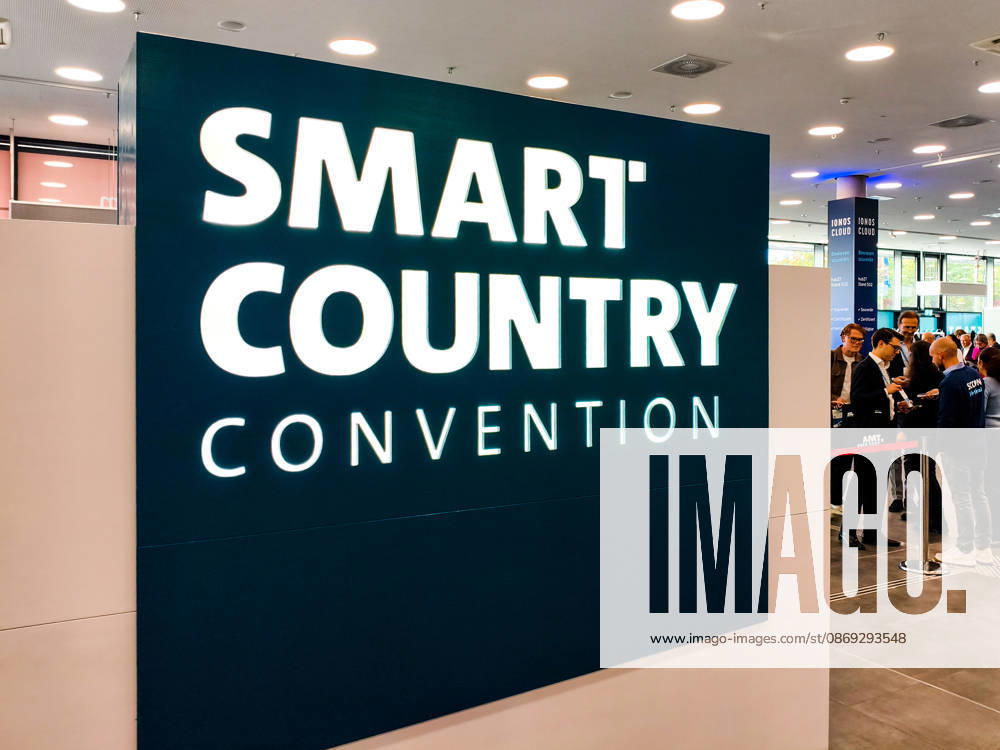 Large, illuminated logo for the Smart Country Convention (SCCON) in the entrance area of Messe Berlin. Visitors and industry professionals stand at the entrance to the Smart Country Convention (SCCON 2026) trade show, Berlin, trade fair, digitization, digital policy, smart city, smart