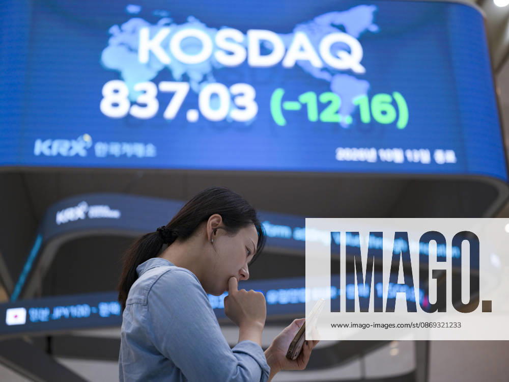 South Korea Stocks Plunge As KOSPI Drops Sharply At KRX In Seoul A Korea Exchange (KRX) employee looks at her smartphone in front of a board displaying the closing KOSDAQ index at 837.03 (-12.16) in Yeouido, Seoul, South Korea, on October 13, 2026. Seoul Seoul South Korea
