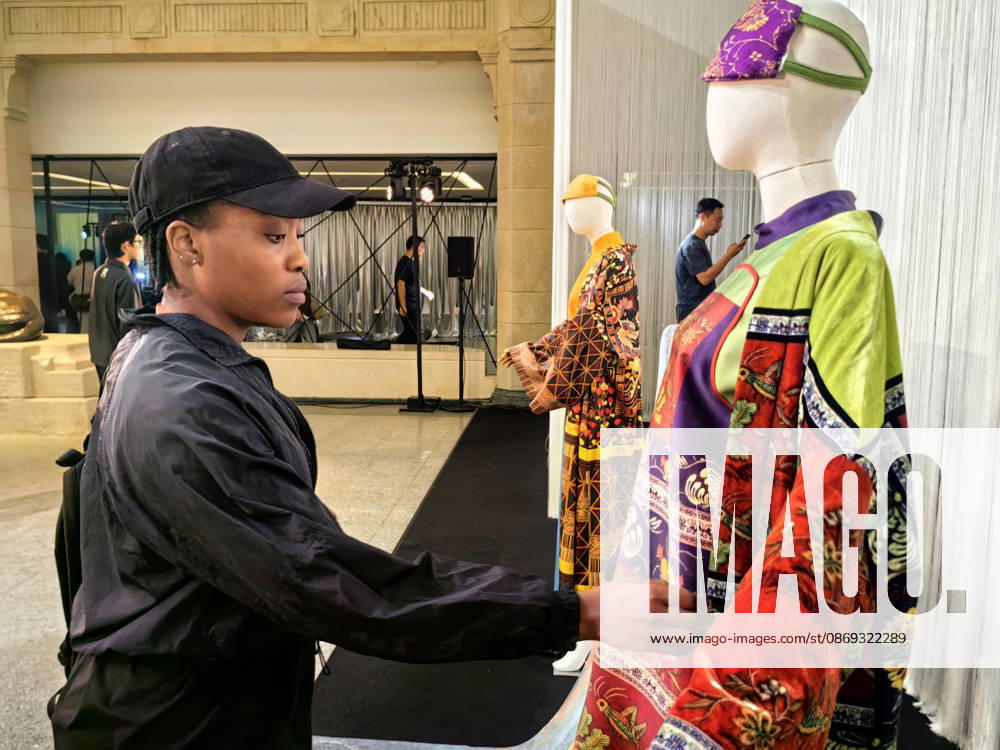 Visitors view contemporary clothing designs featuring traditional Miao embroidery and other Guizhou intangible cultural heritage patterns during the Shanghai Fashion Week Oriental New Chinese Style autumn series event on October 13, 2026 in Shanghai, China. The event, themed Living Heritage, is held at the Shanghai History Museum and features an immersive exhibition alongside fashion showcases highlighting the modern transformation of traditional crafts by domestic designers.