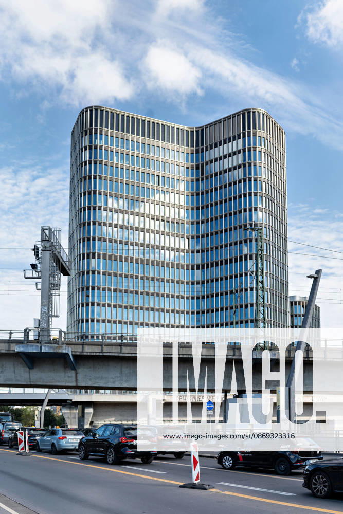 Berlin, 13.10.2026: Autos stehen im Stau auf einer Straße unterhalb einer Bahnbrücke, dahinter ragt das Hochhaus des neuen DKB-Campus in der Europacity in Berlin-Mitte auf. Die Deutsche Kreditbank AG (DKB) hat ihren neuen Hauptsitz heute offiziell eröffnet. Der von Kleihues + Kleihues entworfene, rund 82 Meter hohe Komplex besteht aus drei Gebäudeteilen mit fünf, elf und 19 Geschossen und rund 35.000 Quadratmetern Mietfläche; entwickelt wurde er von der CA Immo unter dem Projektnamen Upbeat. Rund 2.600 Mitarbeitende des DKB-Konzerns, die bislang auf mehrere Berliner Standorte verteilt waren, arbeiten nun gemeinsam im Campus. Die DKB ist Exklusivmieterin und hat einen Mietvertrag über 15 Jahre abgeschlossen. DKB eröffnet neuen