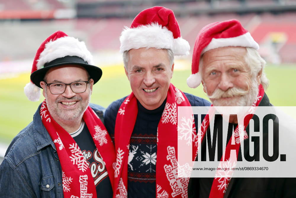 Musician Björn Heuser, choir director Michael Kokott of the St. Stephan Youth Choir, and musician Henning Krautmacher pose wearing Santa hats at the press conference for the 10th annual Loss mer Weihnachtsleeder singe sing-along concert, which will take place this year on December 22 and 23, 2026, at Cologne’s RheinEnergie Stadium and is expected to draw over 90