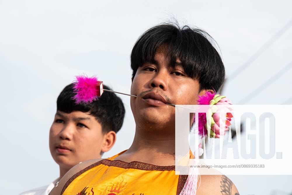 A devotee with a skewer piercing her cheek participates in a street procession during the Vegetarian Festival..The annual Vegetarian Festival is held in Bangkok and many parts of southern Thailand, including Trang, Phatthalung, and Phuket, where worshippers refrain from eating animal products over the nine days, coinciding with the celebration of the Nine Emperor Gods. Trang Thailand - ZUMAs197 20261013_aaa_s197_176