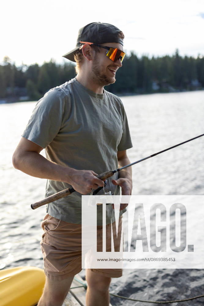 Happy guy with a fishing rod by the water Newport, Washington, United States R_XICN261005B-2132113-01 ,model released, Symbolfoto ,property released