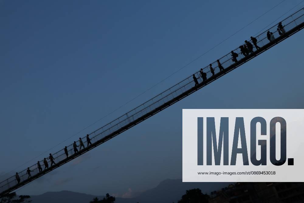 Nepal Bridge Restores Flood-Hit Access NUWAKOT, NEPAL, OCTOBER 14, 2026: Residents cross a newly built suspension bridge over the Trishuli River in Nuwakot, restoring access between communities affected by flash floods. Flooding destroyed bridges and damaged roads in the district, disrupting travel and access to essential services. NUWAKOT Nepal