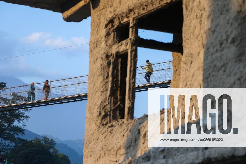Nepal Bridge Restores Flood-Hit Access NUWAKOT, NEPAL, OCTOBER 14, 2026: Residents cross a newly built suspension bridge over the Trishuli River in Nuwakot, restoring access between communities affected by flash floods. Flooding destroyed bridges and damaged roads in the district, disrupting travel and access to essential services. NUWAKOT Nepal