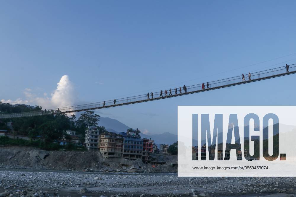 NUWAKOT, NEPAL, OCTOBER 14, 2026: Residents cross a newly built suspension bridge over the Trishuli River in Nuwakot, restoring access between communities affected by flash floods. Flooding destroyed bridges and damaged roads in the district, disrupting travel and access to essential services. Nuwakot Nepal - ZUMAq101 20261014_zna_q101_127