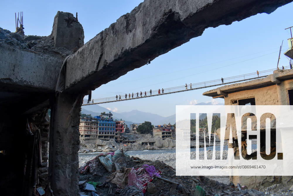Aftermath of flash floods in Nepal NUWAKOT, NEPAL - OCTOBER 14 : People walk across a newly built suspension bridge over the Trishuli River, Nuwakot district, Nepal on October 14, 2026. Road and pedestrian connectivity has been restored with the construction of a new suspension bridge over the Trishuli River, allowing local residents to cross the river after the devastating floods damaged bridges and other infrastructure in the area. Sunil Pradhan Anadolu Nuwakot Nepal. Editorial use only. Please get in touch for any other usage.
