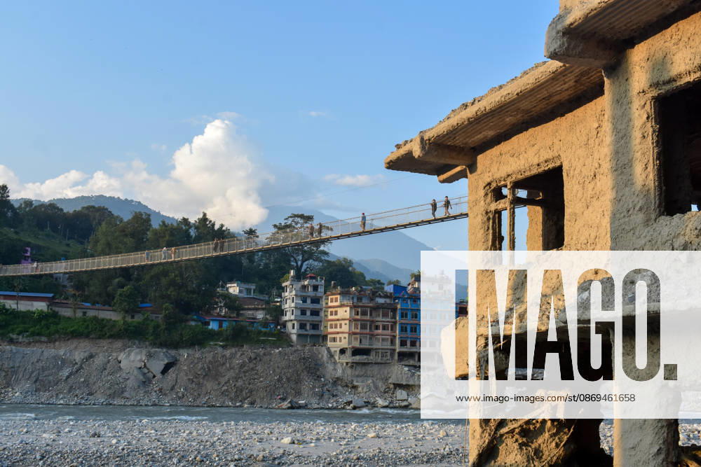 Aftermath of flash floods in Nepal NUWAKOT, NEPAL - OCTOBER 14 : People walk across a newly built suspension bridge over the Trishuli River, Nuwakot district, Nepal on October 14, 2026. Road and pedestrian connectivity has been restored with the construction of a new suspension bridge over the Trishuli River, allowing local residents to cross the river after the devastating floods damaged bridges and other infrastructure in the area. Sunil Pradhan Anadolu Nuwakot Nepal. Editorial use only. Please get in touch for any other usage.
