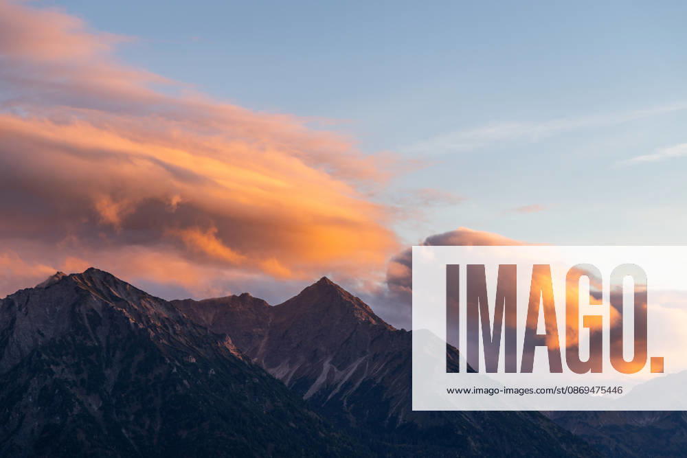 Autumn Evening in the Allgäu: The clouds in the sky glow in the evening sun above the peaks of the Allgäu Alps, Bad Hindelang, Bavaria, Germany
