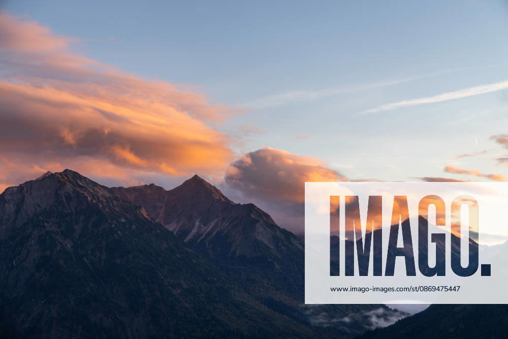 Autumn Evening in the Allgäu: The clouds in the sky glow in the evening sun above the peaks of the Allgäu Alps, Bad Hindelang, Bavaria, Germany
